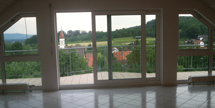 Blick aus dem Wohnbereich über den Balkon, Kirchturm und Hügel
