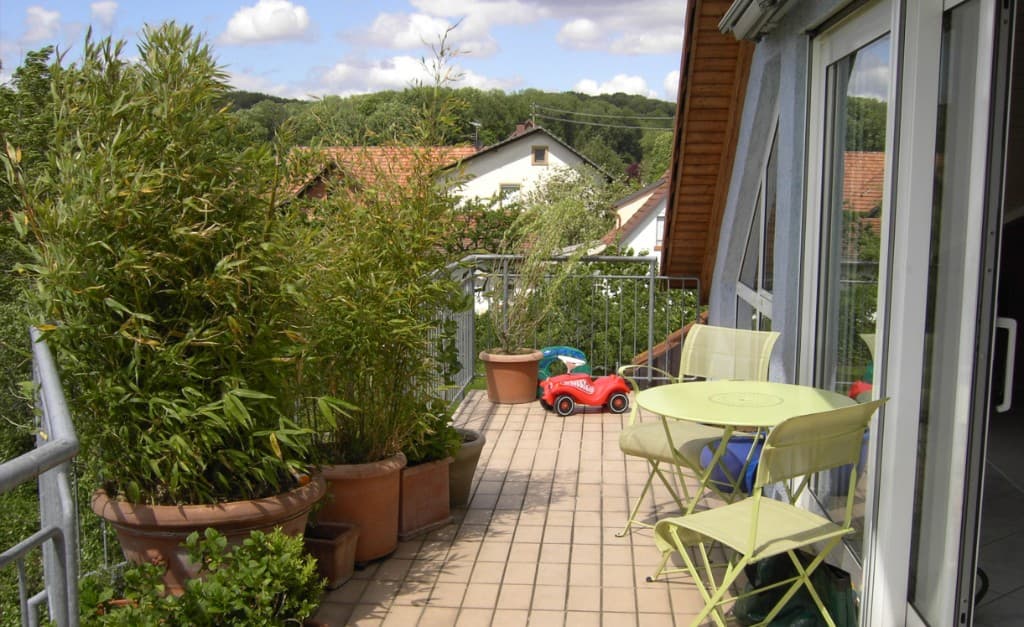 Balkon mit Pflanzen, Tisch und Stühlen, Blick ins Grüne