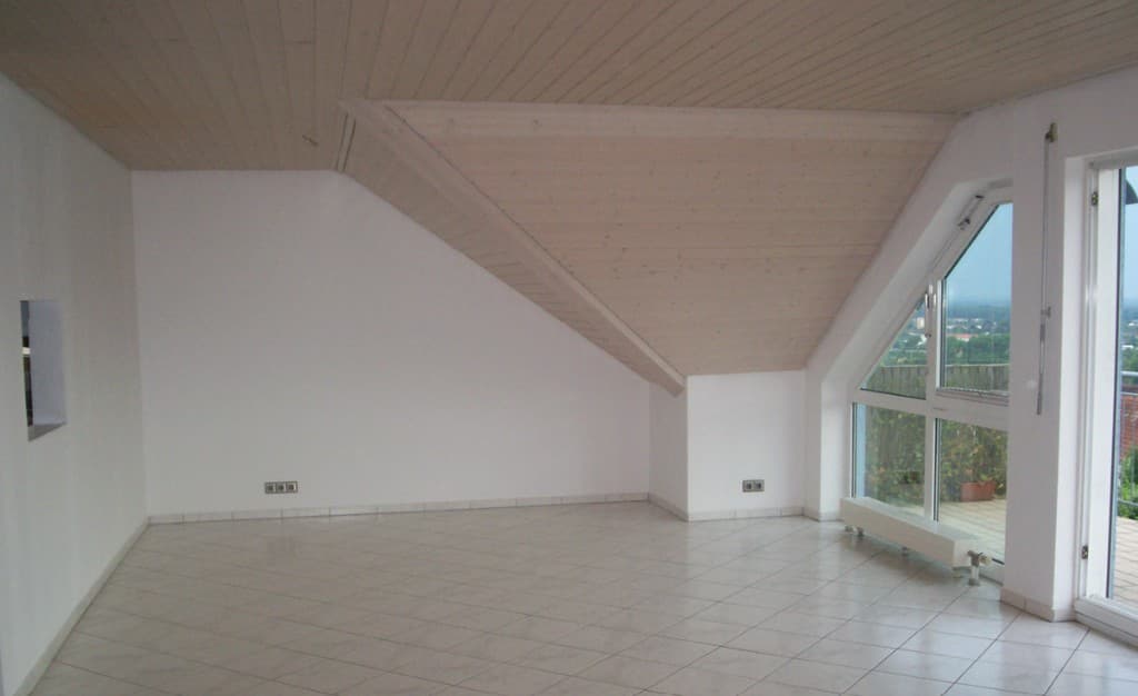 Wohnbereich mit Holzdecke, Dachschräge und Fenster zum Balkon